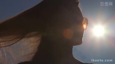 年轻女子戴着墨镜的脸挡住了太阳镜片的光斑